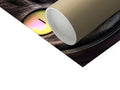 A cat is laying on the body of a white paper roll with some wrapping paper close