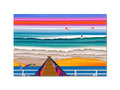 Four colorful surf boards surrounded by sand.