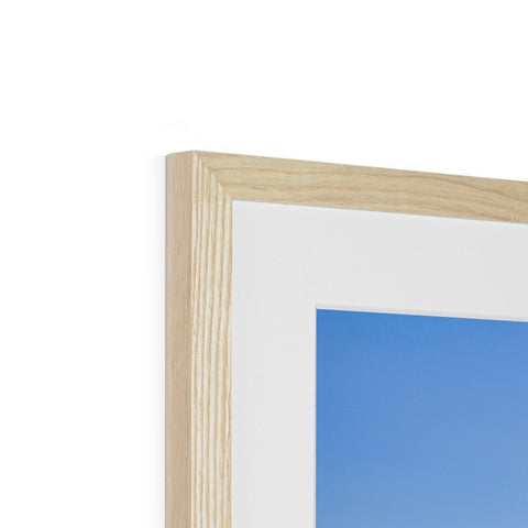 A blue wooden picture frame is standing next to a white piece of wood