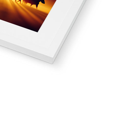 A picture frame with a white and black photo is holding an imac.