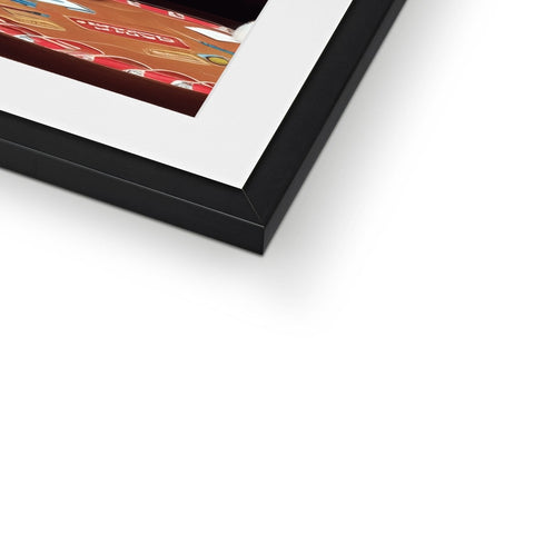 A close up view of a framed photo framed on a wall, in a red wood