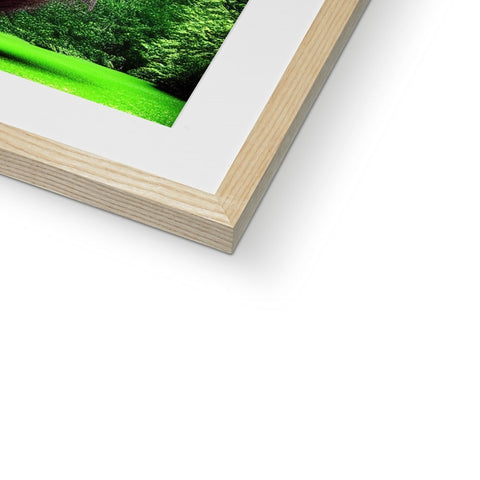 A green book sitting on top of a frame with a large picture and some green grass