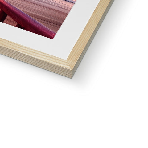 A blue and red photograph is in the center of a framed picture frame.