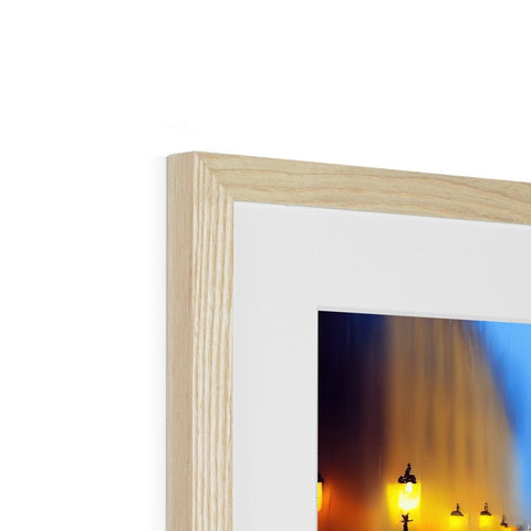 A framed wooden picture frame with a blue candle sitting on top of a fireplace.