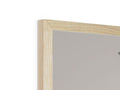 A picture of wood frame is sitting in a tall mirror on top of a white table