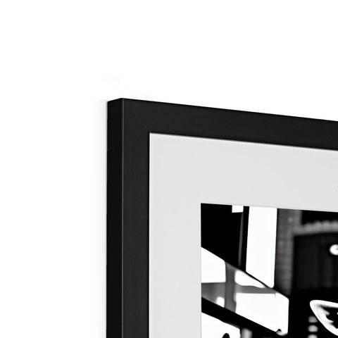 A black and white picture frame containing a photograph of a flat display television.