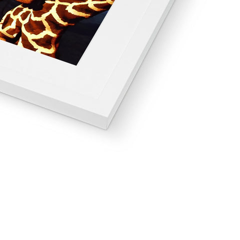 A white picture of a giraffe sitting in a picture frame near a book.