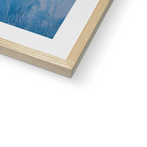 A blue and white picture inside of a wood framed frame with a photo on top.