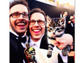 a picture of a cat and two men holding an award