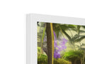 A very tropical picture frame with a tropical view and flowers and plants on the side of