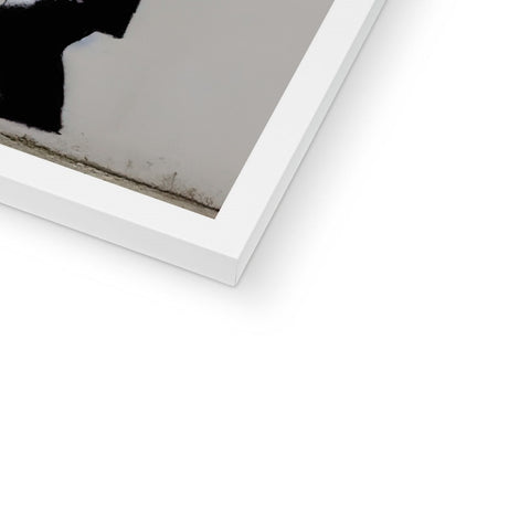 A white  photo sitting on top of a picture frame on a wall in a living