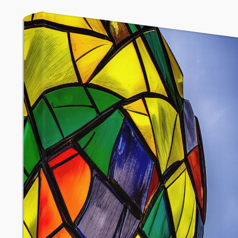 A stained glass art glass wall display with sculptures near colorful tables and chairs.