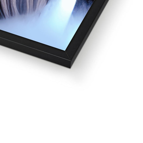 A picture frame with a photograph on it in front of a computer monitor in light blue
