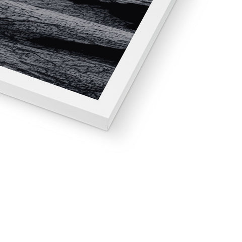 A white square framed photo that sits in front of a paper stack.