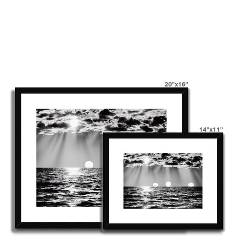 A picture frame with a black and white image of a view of sea and water.