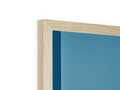 A blue photo frame inside of a wood framed frame sitting together on a floor.