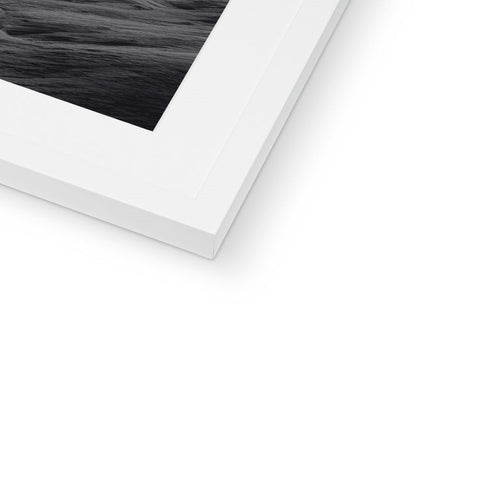 A white picture of a river and sea is on top of a photo frame.