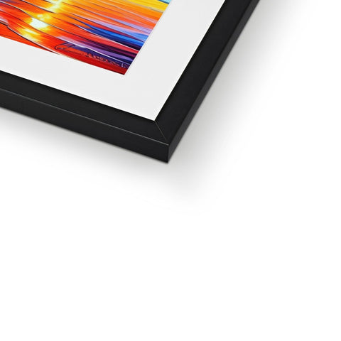 A colorful framed picture of art on a table with a picture frame.