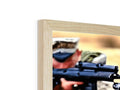 A picture frame with two magazine magazines sitting on a wooden surface.  )