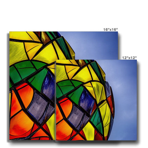 A colorful kite tied to decorative ceramic tile in a room with lights.