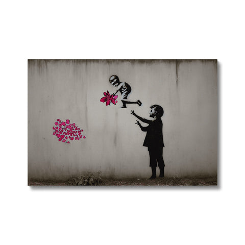 A child putting a spray on some art print and a flower.