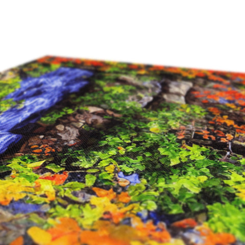 A green blanket that folds into a puzzle with pieces of art printed on it.