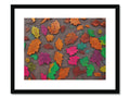 Fall leaves on a colorful wall next to art print hanging on a wall