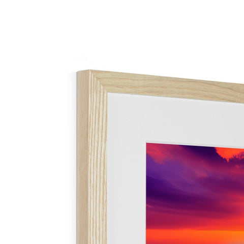 A black and white picture frame with a picture of a sunset on top of a wooden