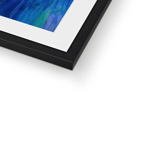 A blue and white framed photo sitting on top of a bed of a wooden frame.