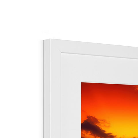 A white photo frame on a wall with artwork on it.