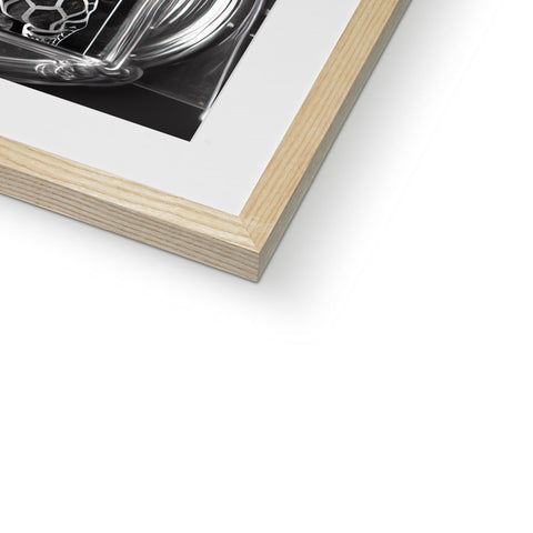 A softcover picture in a white frame on a table next to a metal picture frame