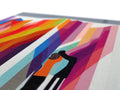 A print blanket on a picnic table covered with a bunch of colored paper that resembles rainbow