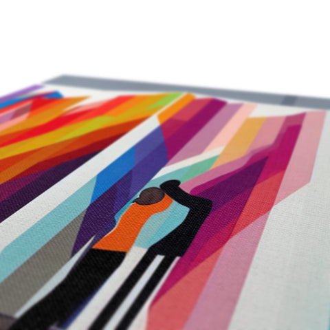 A print blanket on a picnic table covered with a bunch of colored paper that resembles rainbow
