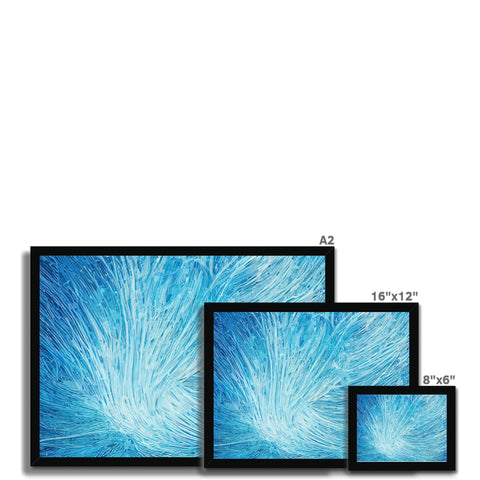 A wall tile and picture frames in a white room holding various TVs.