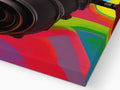A photograph of a colorful print umbrella next to a small white camera lense with a