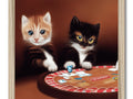 Two kittens sitting under a wooden table in a casino with black and white cards holding various