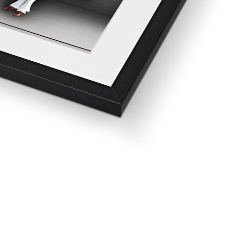 A picture frame displaying a white and black picture of a framed photo in a hallway.