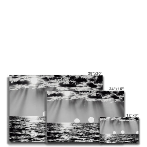 A white sheet on a bed surrounded by black and white photos of water with a pin