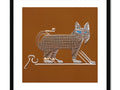 An Egyptian cat sitting on a piece of decorative paper next to an image of a door
