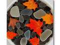 Fall foliage on a black and white tile floor with pebbles on it.
