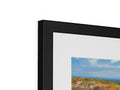 A picture frame with a photo of a beautiful view of a rocky island.