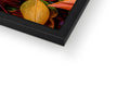 A white picture frame with a picture of autumn foliage on top of a black screen looking