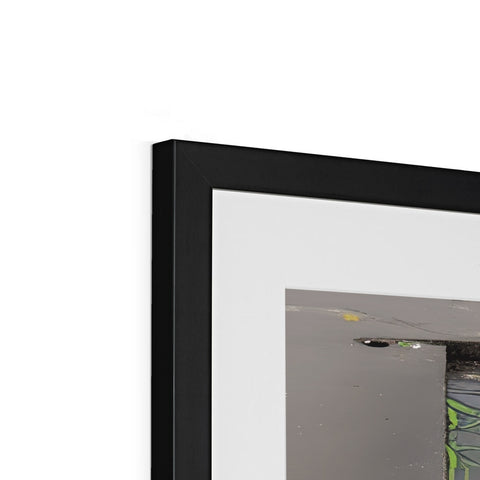 A picture frame framed in black is positioned next to several flat screen laptops on a table