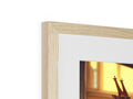 Wooden picture frame with a giraffe standing in a doorway on a wall.