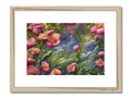 A colorful art print sitting on a bed of flowers in a small stream water.