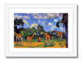 Three giraffe are standing on a grassy hill surrounded by trees looking at the water