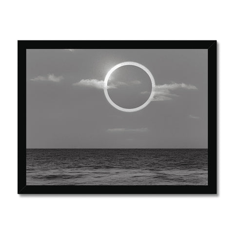 a mirror with a black and white photo of an eclipse over a water blue ocean
