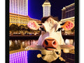 A picture frame with a white picture of a cow on a street in Las Vegas.