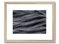 An art print of a waterfall on a beach with a driftwood background.
