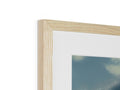 An empty white picture frame hanging in a picture frame on a wall.